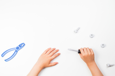 Top view on childs hands playing with colorful toys tools on the white background.の写真素材