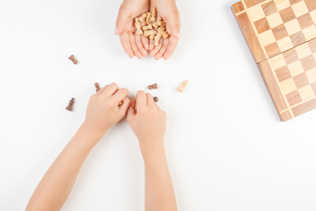 Chess board with chess pieces and a playing kids hand.の写真素材