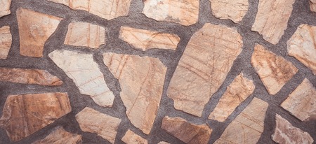 Masonry wall of stones with irregular pattern texture background