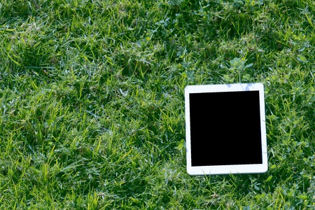 Tablet computer lying on the grassの写真素材