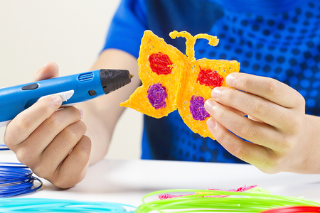 Kid hands creating with blue 3d pen