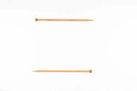 A pair of wooden knitting needles on white background.の写真素材