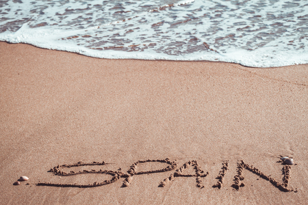Spain written in the sand at the beachの写真素材