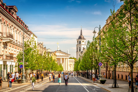 Vilnius, Lithuania - May 1, 2018: View to Vilnius city street -Gedimino avenue, Vilnius Cathedral and bell tower with people walking and riding bike in sunny day.のeditorial素材