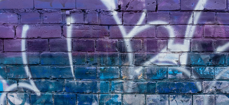 Fragment of colorful graffiti drawing made with aerosol paints on a brick wallの写真素材