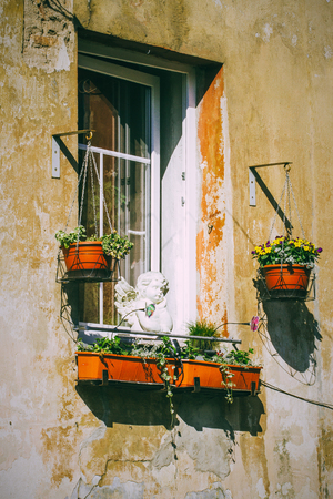 Old window with colorful flowers pot on street of Vilnius, Lithuaniaの写真素材