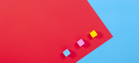 Three colorful wooden blocks on blue and red backgroundの写真素材