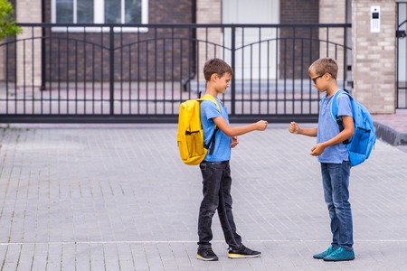 Two boys playing rock paper scissors game after schoolの写真素材