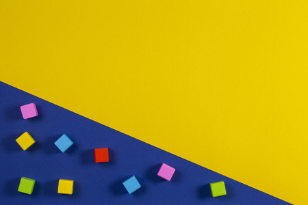 Baby kid toys background. Colorful plastic construction blocks and wooden cubes on yellow and blue backgroundの写真素材