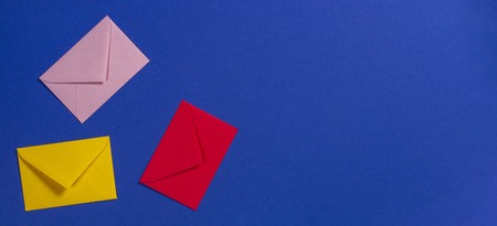 Colorful envelopes on blue background, top viewの写真素材