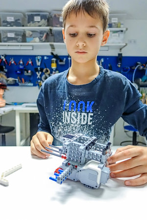 Vilnius, Lithuania - November 23, 2018: Kid making Lego robot mindstorms. Robotic, learning,...