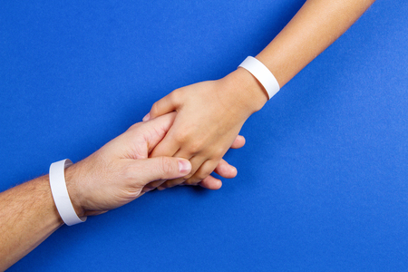 Mockup template blank paper wristband, bracelet on man and kid arms, blue color background