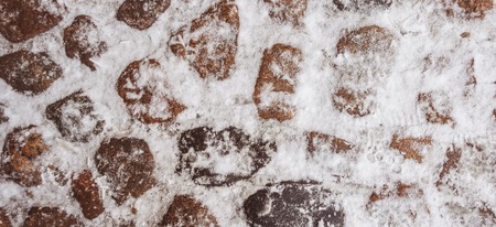 Old stone pavement covered with snow in winter