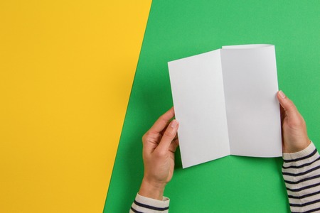Woman hands holding blank white flyer brochure booklet. Mockup sheet template advertising booklet on...