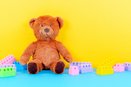 Baby kids toys background with teddy bear and colorful building blocks bricksの写真素材