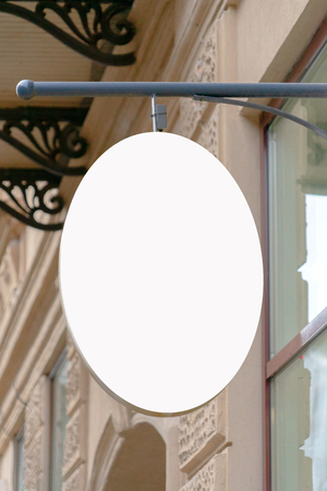 Mock up. Blank oval shape signboard on the wall of classical architecture buildingの写真素材