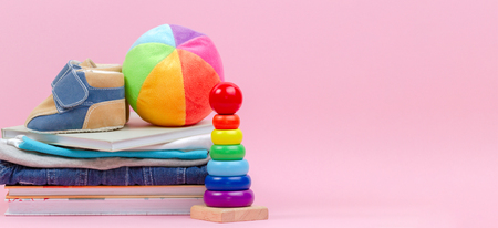 Kid toys, books and clothes on pink backgroundの写真素材