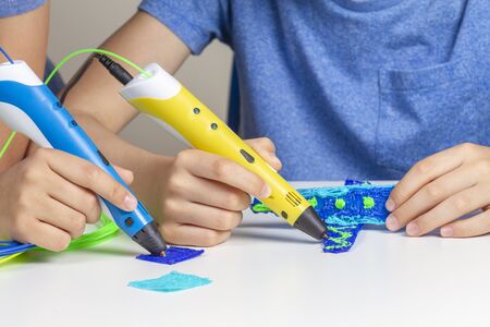 Kids hands creating with 3d printing pens