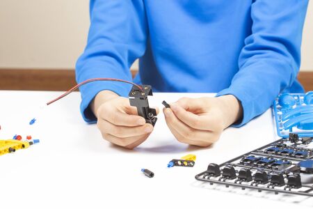 Child hands making robot car. Robotic, learning, technology, stem education for children backgroundの写真素材
