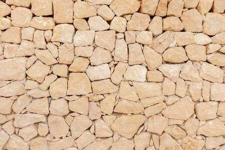 Masonry wall of stones with irregular pattern texture backgroundの写真素材