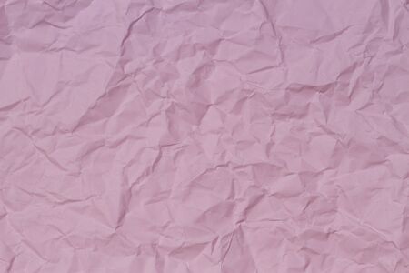 Pink crumpled wrinkled paper texture backgroundの写真素材