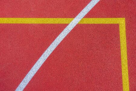 Colorful sports court background. Top view to red field rubber ground with white and yellow lines...