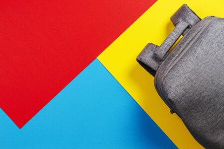 Top view of gray backpack on yellow, blue and red backgroundの写真素材