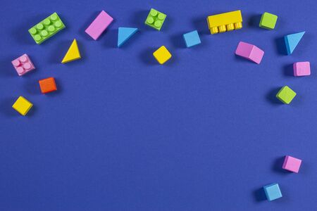 Baby kid toys background. Top view to colorful wooden cubes and plastic construction blocks on blue backgroundの写真素材