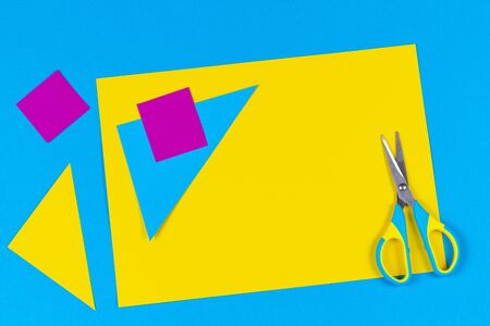 Top view to scissors and colored paper on tableの写真素材