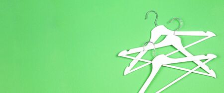 White wooden hangers on pastel green background. Shopping, sale, promo, social media, new season conceptの写真素材