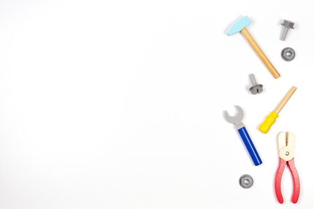 Wooden kids toys screwdriver, plier, bolts, nuts and other construction tools frame on white background. Top view, flat layの写真素材