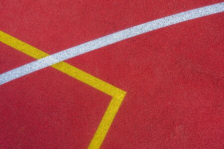 Colorful sports court background. Top view to red field rubber ground with white and yellow lines outdoors.の写真素材