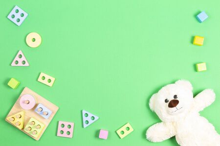 Baby kid toys background. Teddy bear and wooden pastel color geometry educational toy for children on light green backgroundの写真素材