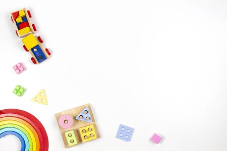 Baby kids toys background. Wooden educational geometric stacking blocks toy, wood rainbow, and colorful blocks on white background. Top view, flat layの写真素材