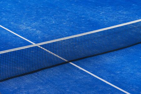 Blue paddle tennis net and court field background.の写真素材