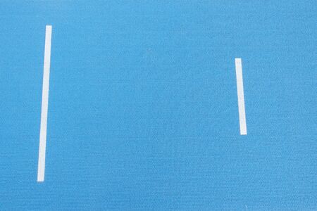 Sport background. Blue running track with white lines in sport stadium. Top view