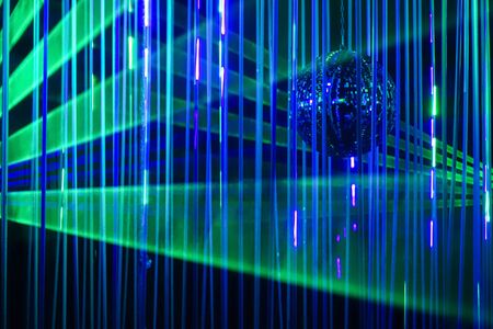 Green and blue laser beams on black background. Laser show rays stream.