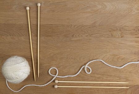 Wooden knitting needles and ball of yarn on wood background. Top viewの写真素材