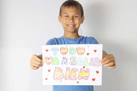 Coronavirus pandemic self quarantine in Spain. Kids at home drawing pictures with spanish words Todo va salir a bien - Everything will be fineの写真素材