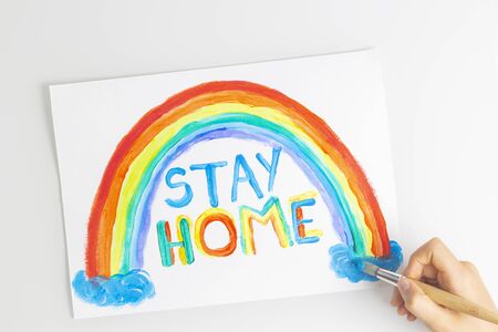Kid painting during quarantine at home. Rainbow with words Stay at home. Social media campaign for...