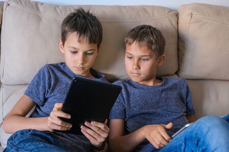 Children using digital tablet computer at home. Technology, online learning, distance education,...