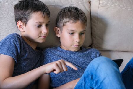 Children using digital tablet computer at home. Technology, online learning, distance education,...