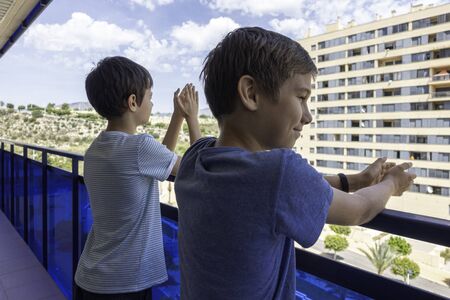 Applause to medical staff. Family clapping hands, applauding from balcony to support doctors, nurses, hospital workers during Coronavirus pandemic quarantineの写真素材