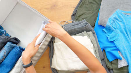 Vertical storage of clothing, Marie Kondo tidying up method, room cleaning concept. Woman hands...