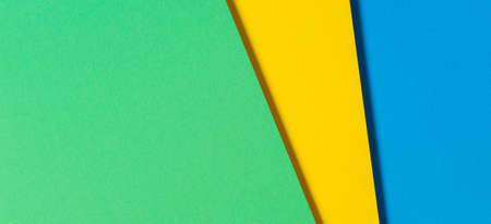 Abstract color papers geometry flat lay composition banner background with blue, yellow and green...