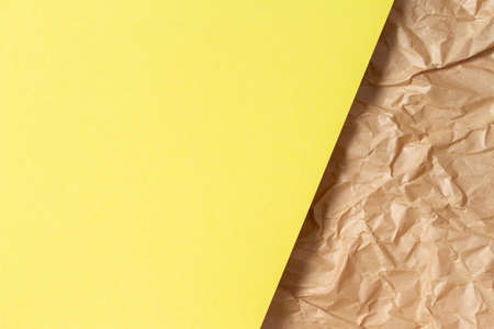 Abstract geometric paper texture background. Blank yellow color paper sheet over recycle crumpled brown paper backgroundの写真素材