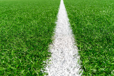 Green artificial grass turf soccer football field background with white line boundary. Top view