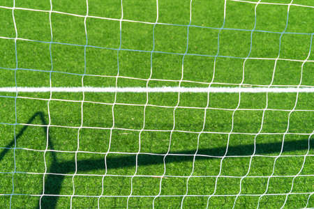 Close up of football soccer goal net with green grass background