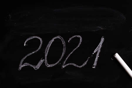 writing 2021 on black chalkboard, closeup
