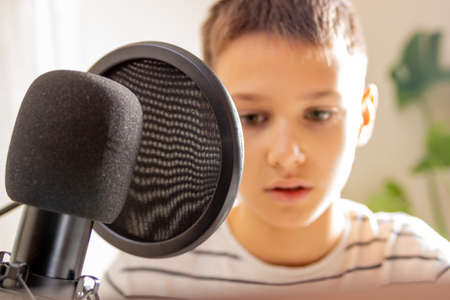 Kid talking into microphone. Techology, online learning, remote education, distance learning at homeの写真素材